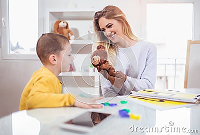 Little boy during lesson with his speech therapist. Stock Photo