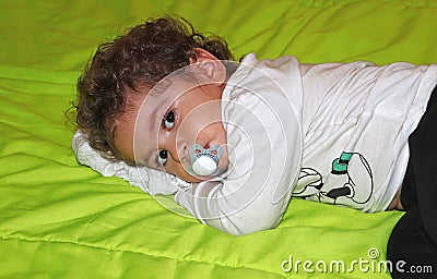 A little boy lies with a pacifier Stock Photo