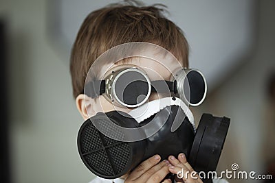Little boy look toward in black respirator and black glasses blurred background Stock Photo