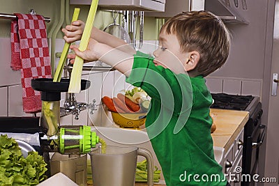 Little boy making green juice Stock Photo