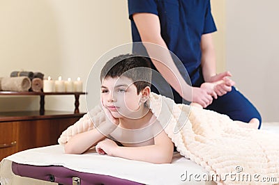 Little boy patient at reception at a professional masseuse. Foot Massage Therapy Stock Photo
