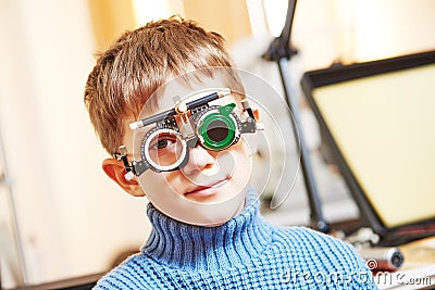 Little boy with phoropter at ophthalmology clinic Stock Photo