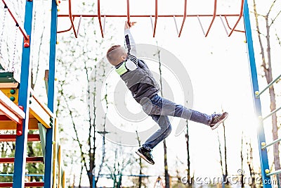 Little boy play on playground with blur park background Stock Photo