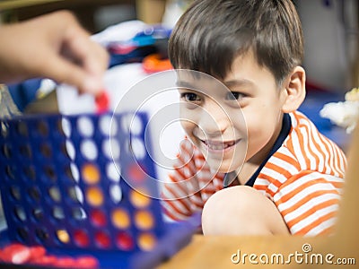 Little boy playing connect four game soft focus at eye contact Stock Photo
