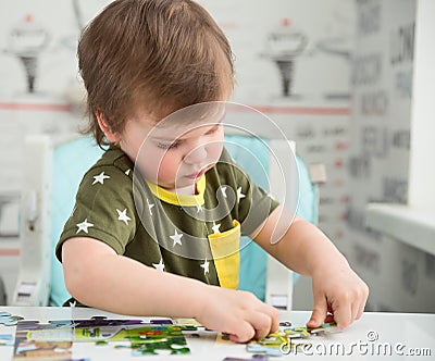 Little boy playing puzzle Stock Photo