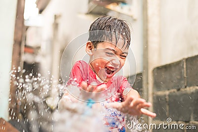 Little boy playing water splash over face Stock Photo