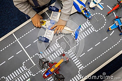 Little boy plays color Lego set on the table. Early training and development. Editorial Stock Photo