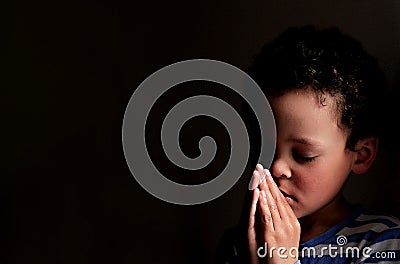 Little boy praying to God with hands held together stock photo Stock Photo