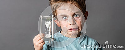 Little boy with questioning eyes holding a scary egg timer Stock Photo