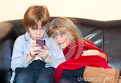 Little boy reading a text message on a smartphone. Stock Photo