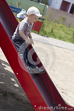 Little boy rids on the slide Stock Photo