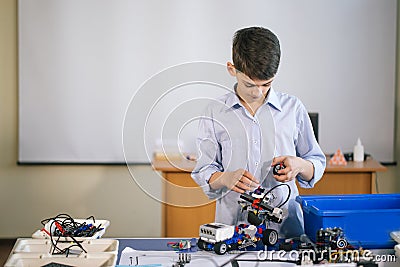 Little boy in robotics school makes robot Stock Photo