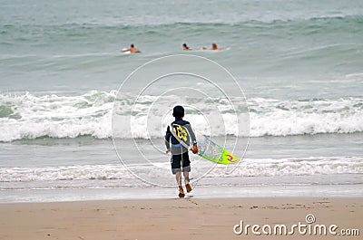 Little boy runs surfing in the ocean Editorial Stock Photo