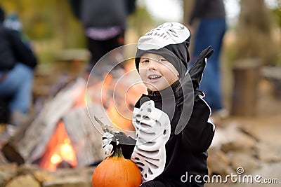 Little boy in scary skeleton costume at halloween celebrations party in forest Stock Photo