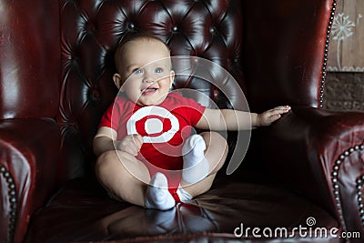 A little boy sits in a leather chair. Happy family life. Man was born Stock Photo