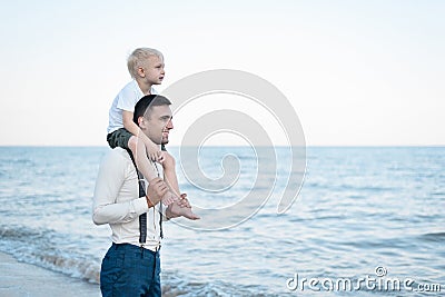 Little boy sits on shoulders of his father. Young handsome man and his son. Older and younger brothers Stock Photo