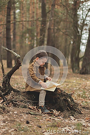 Little cute child is reading in the Forrest Stock Photo