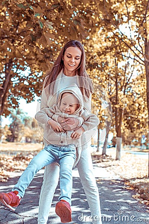 Little boy son, plays mother woman, tenderness and care child, autumn day on street in warm clothes hood, summer on Stock Photo