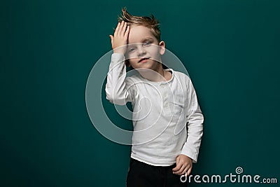 Little Boy Standing in Front of Green Wall Stock Photo