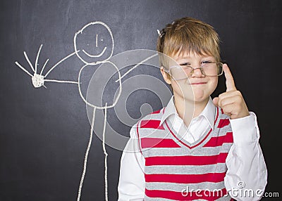 Little boy standing near the blackboard for drawing. Stock Photo