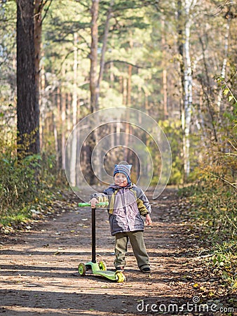 A little boy stands with a scooter in the Park Stock Photo