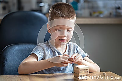 Little boy stands a turret with wooden cubes close up Stock Photo