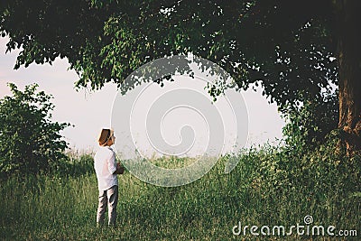 Little boy staying under big linden tree. Soft focus Stock Photo