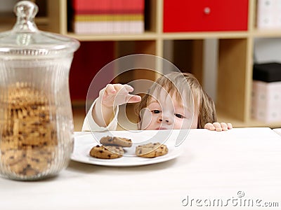 Little boy stealing cookies Stock Photo