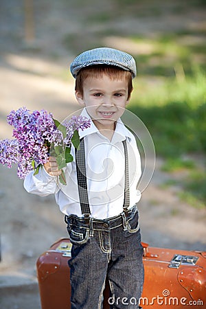 Little boy with suitcase and lilac Stock Photo