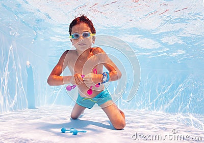 Boy swim underwater take toys in pool with googles Stock Photo