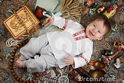 Little boy in a traditional russian shirt surrounded by russian antiques Stock Photo