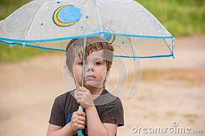 Little boy under umbrella Stock Photo