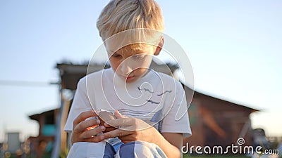 A little boy unfolds and eats a chocolate egg with toys. Stock Photo