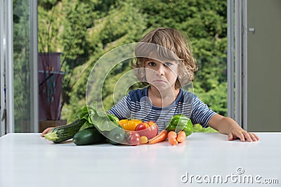 Little boy frowning at his vegetable meal Stock Photo