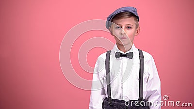 Little boy in vintage clothes looking into camera, isolated on pink background Stock Photo