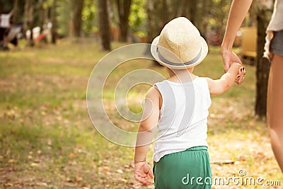 Little boy walking with mom in park. Stock Photo