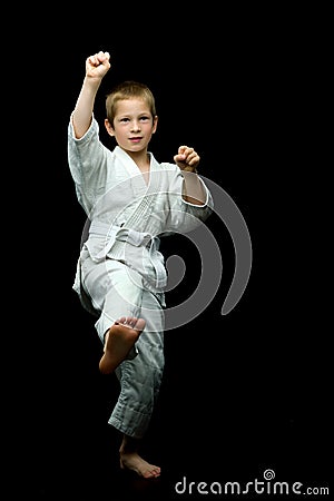 A little boy in a white kimono fulfills blows Stock Photo