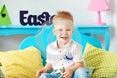 Little boy 2-3 years blond hair sitting on the floor and laughs. Stock Photo