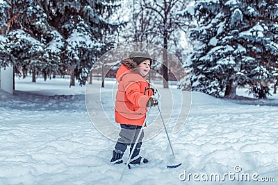 Little boy 3-4 years old, winter children`s skis, happy smiling plays, having fun, active image of children. Background Stock Photo