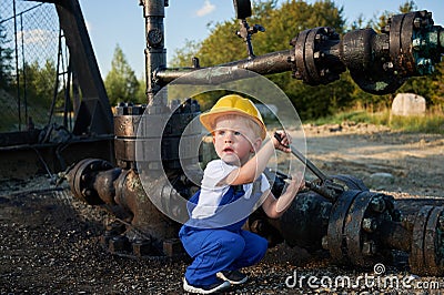 Little boy exploring working tools outdoors near pipeline. Stock Photo