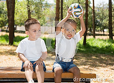 Little boys: African American and caucasian with soccer ball in park on nature at summer. Stock Photo