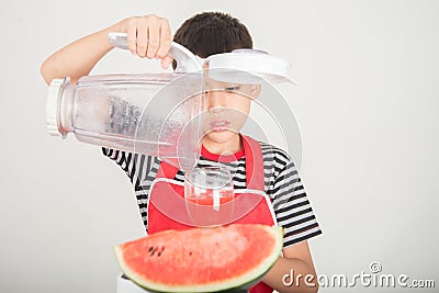 Little boys blend water melone juice by using blender home Stock Photo