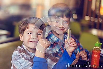 Little boys eating french fries in fast food restaurant Stock Photo