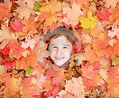 Little Boys Face in Leaves Stock Photo