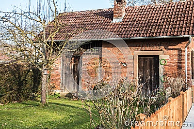 Little brick house with a small garden, tree and fence Stock Photo