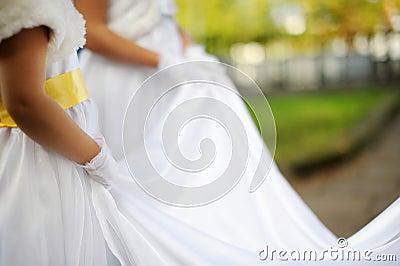 Little bridesmaids holding bride's dress Stock Photo