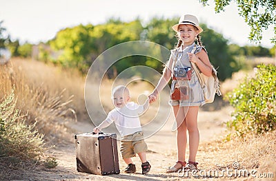 Little brother with an older sister and a large suitcase Stock Photo