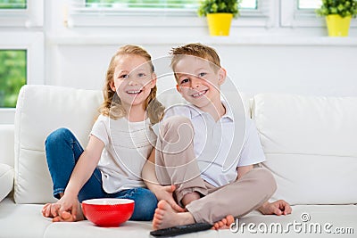 Little brother and sister watching tv Stock Photo