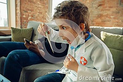 Little caucasian boy as a doctor consulting for patient, working in cabinet, close up Stock Photo