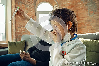 Little caucasian boy as a doctor consulting for patient, working in cabinet, close up Stock Photo